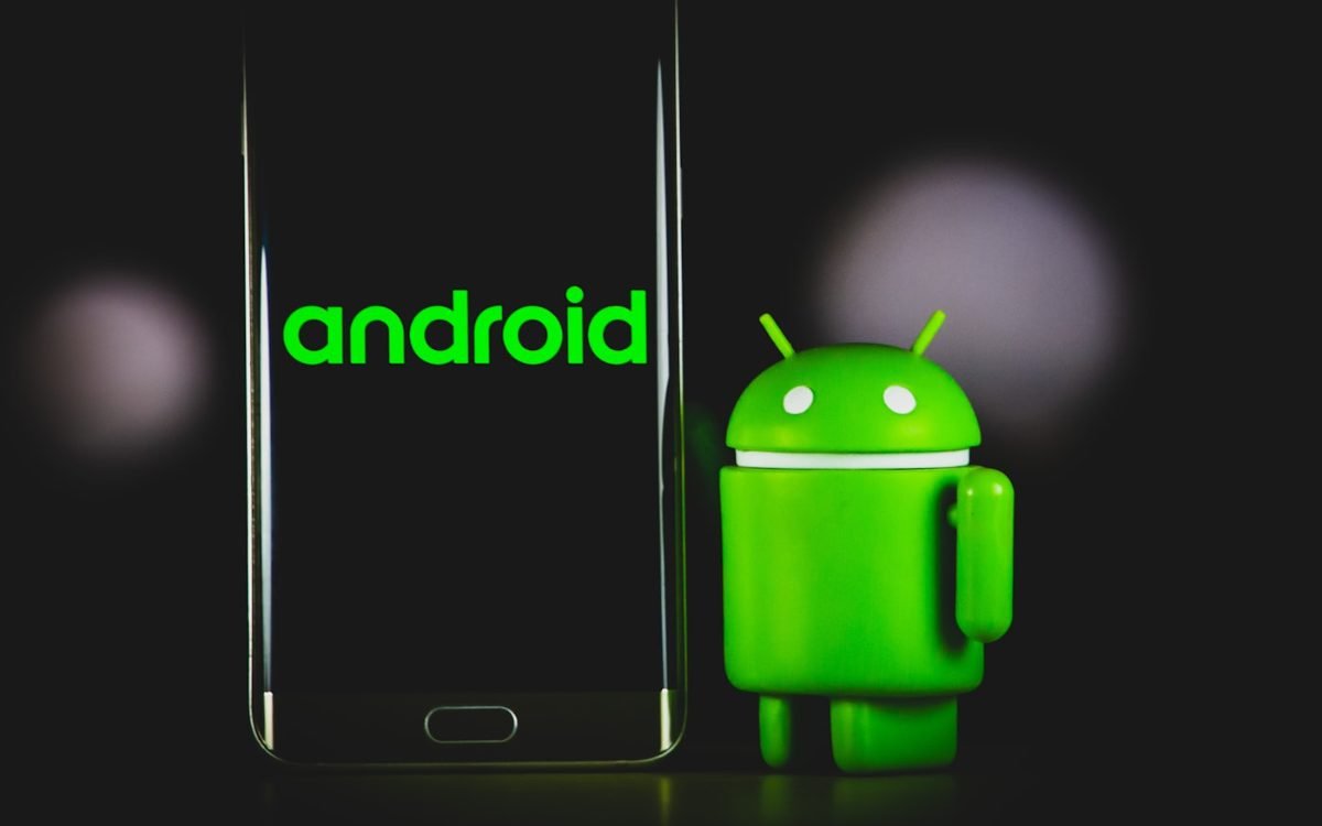 An Android mascot beside a phone showing the Android wordmark